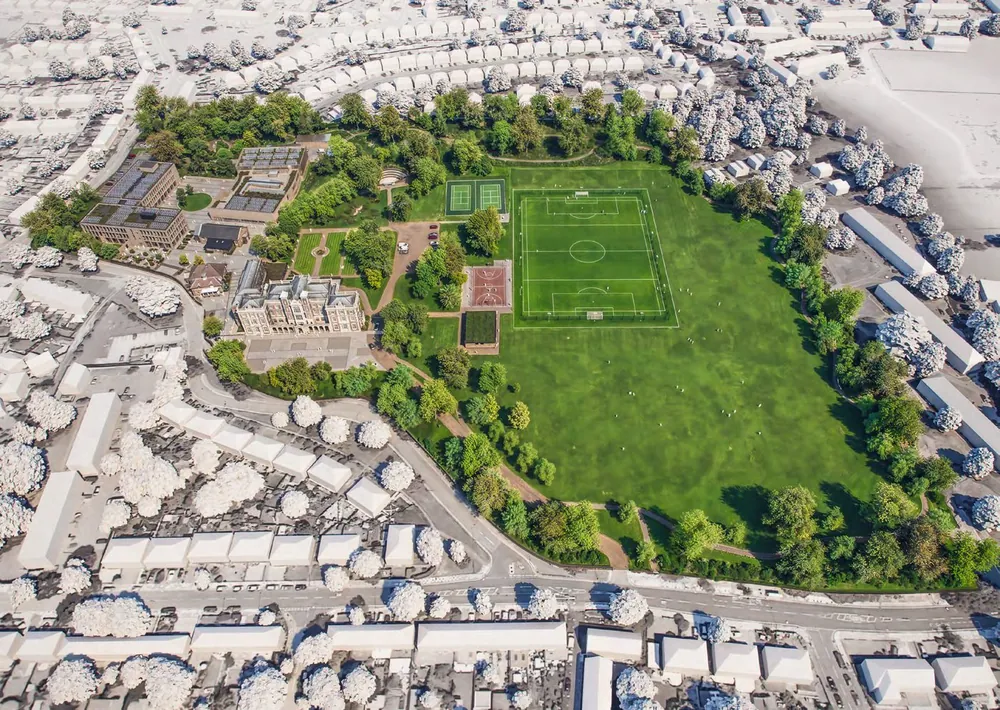 Aerial view of the Kneller Hall campus: the historic main building beside playing fields and an all-weather pitch